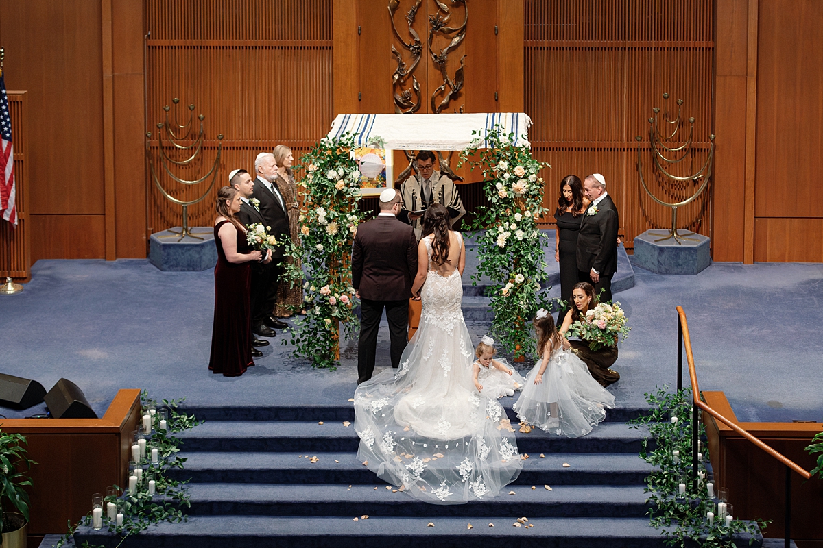 Allie and Nathan's wedding at United Hebrew Congregation beneath a flower-covered chuppah