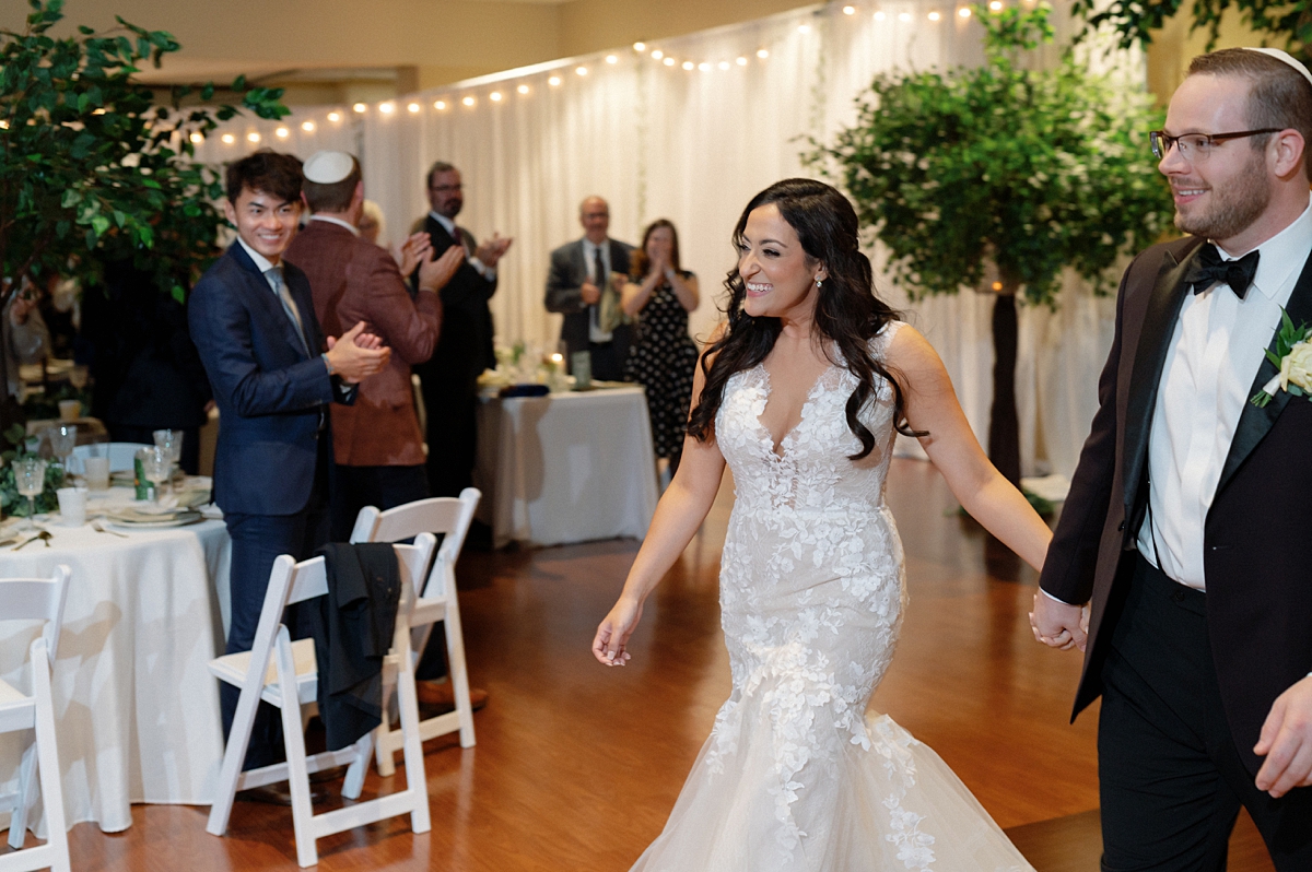 Guests applauding as Allie and Nathan enter their wedding reception