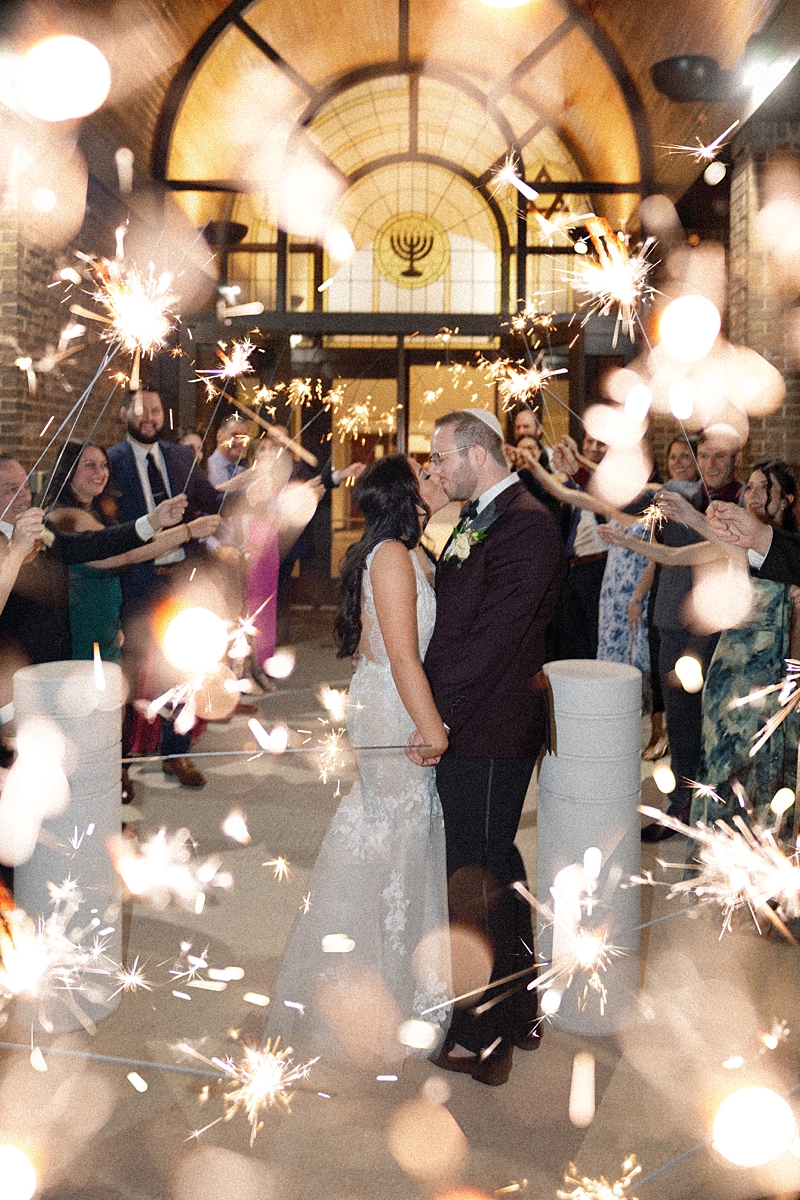 Guests surrounding Allie and Nathan with sparklers at the end of the wedding