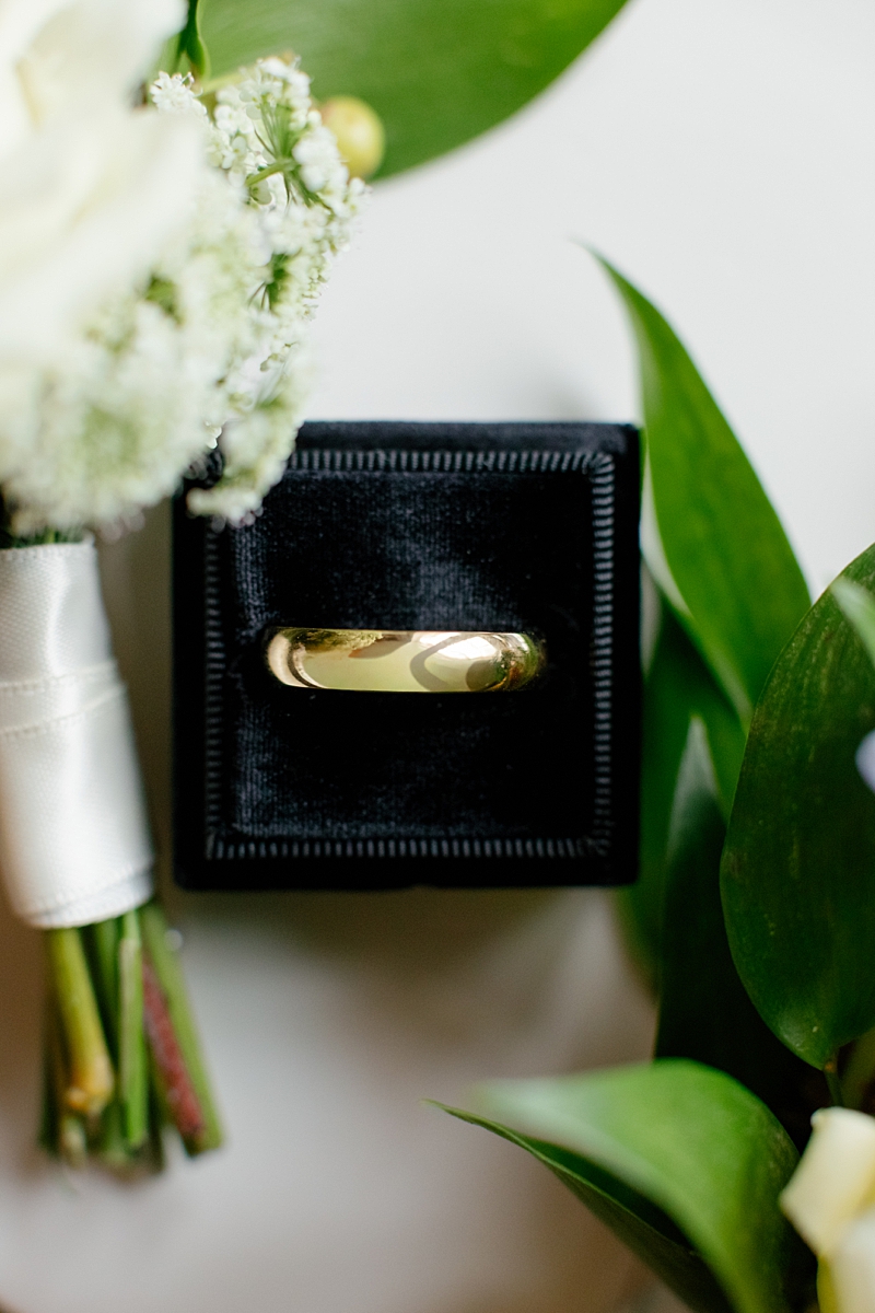 Wedding ring photographed with white flowers