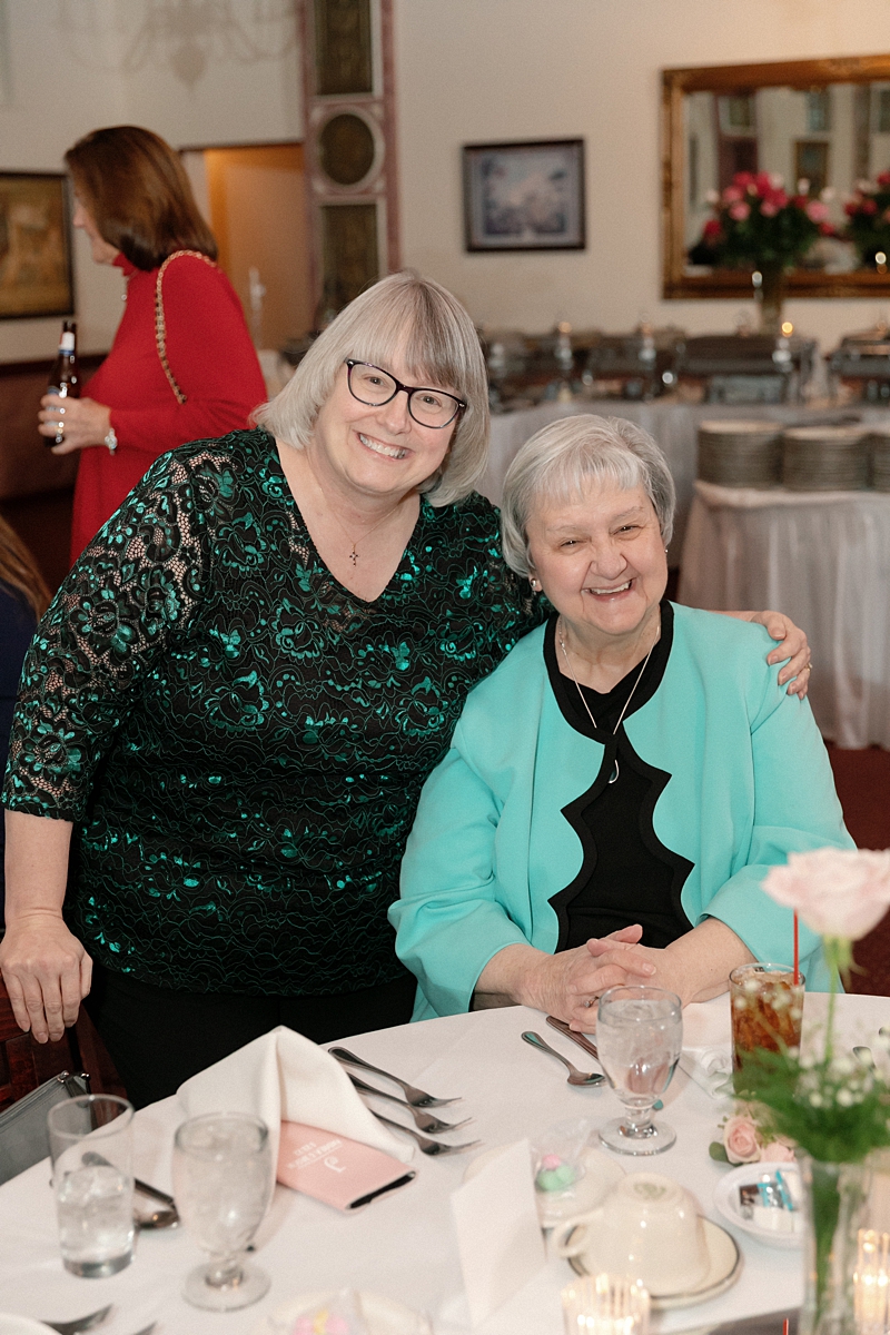 Two wedding guests smiling together during the Rose of the Hill reception