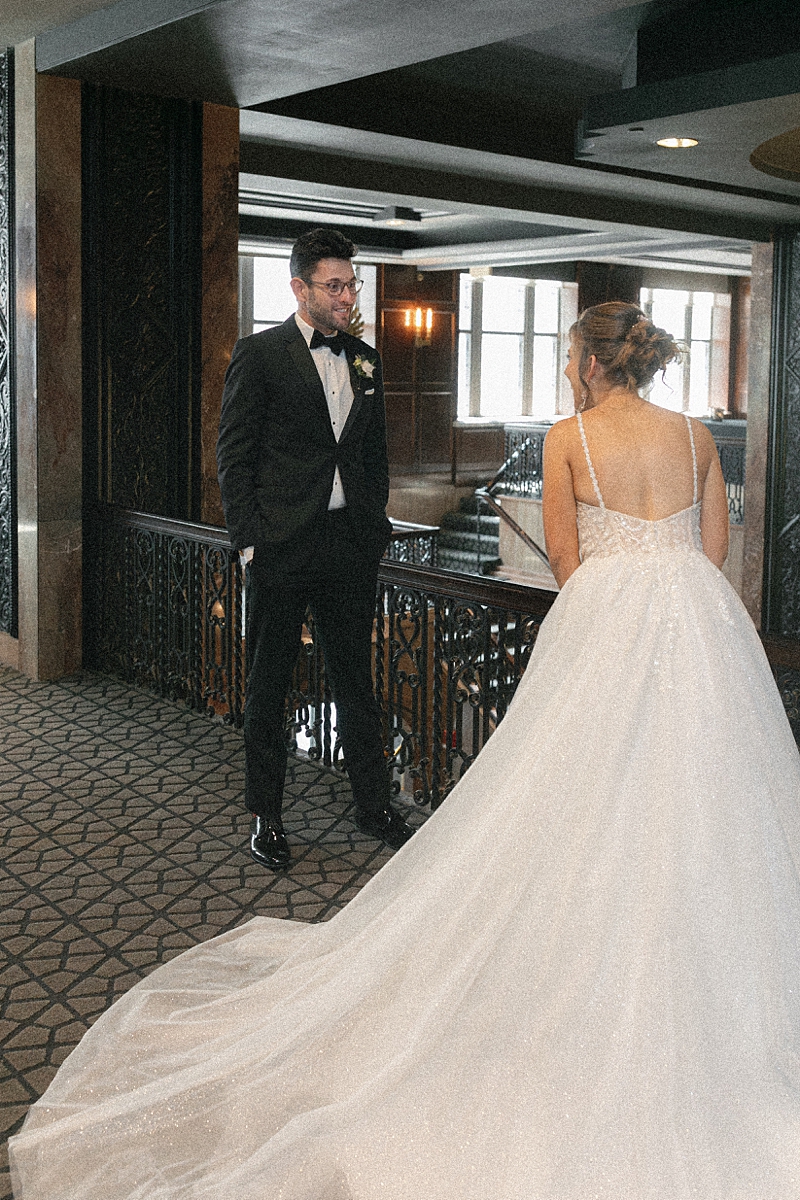 Lauren and Nick's first look at Hotel Phillips with her wedding gown and train in the foreground